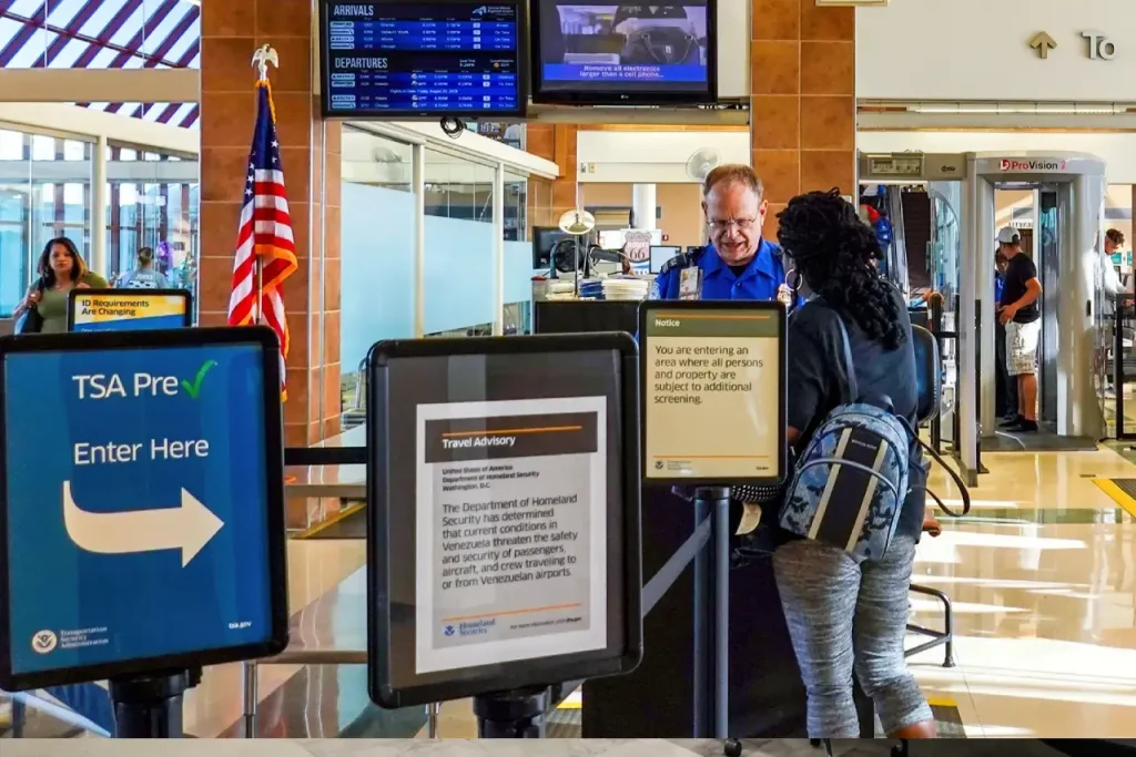 Travelers following airport procedure for TSA ID renewal at counter