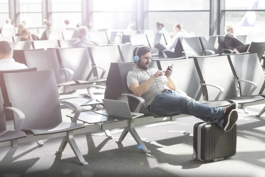 Teen listening to music, relaxing during airport layover downtime