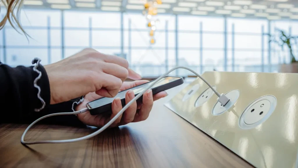 Person charging a cell phone at Miami Airport