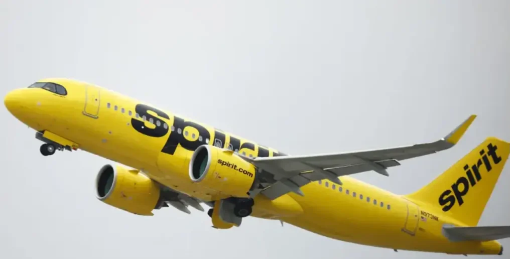 Spirit Airlines aircraft parked at the terminal gates at DFW Airport under clear weather conditions.